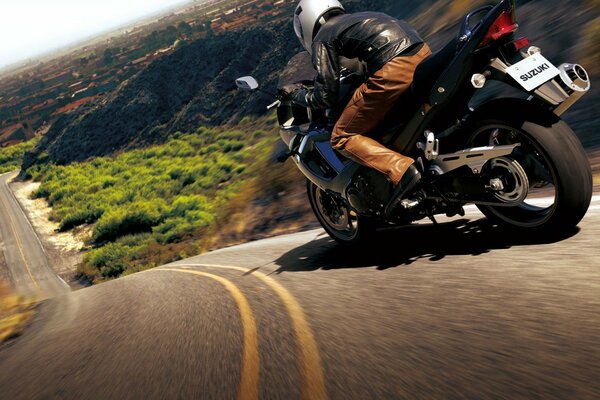 A motorcyclist rushes along the road on the slope