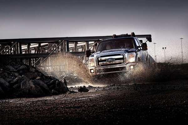 Mud splashes from under the wheels of a powerful Ford