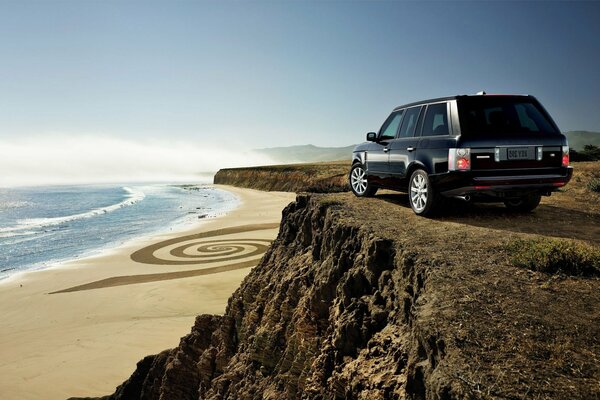 SUV auf einem Berg vor dem Hintergrund von Strand und Meer