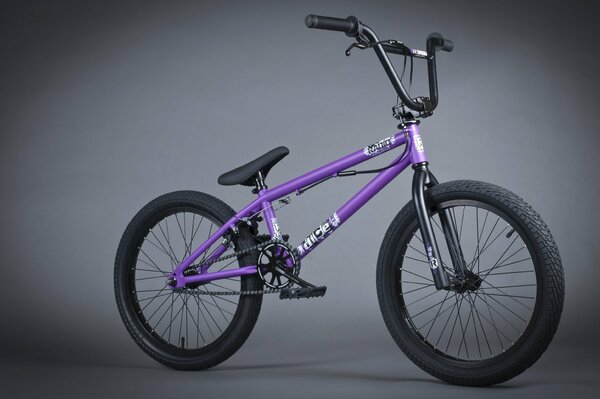 Vélo BMX violet sur fond gris