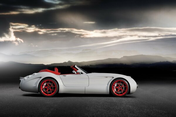 White car with red wheels in nature