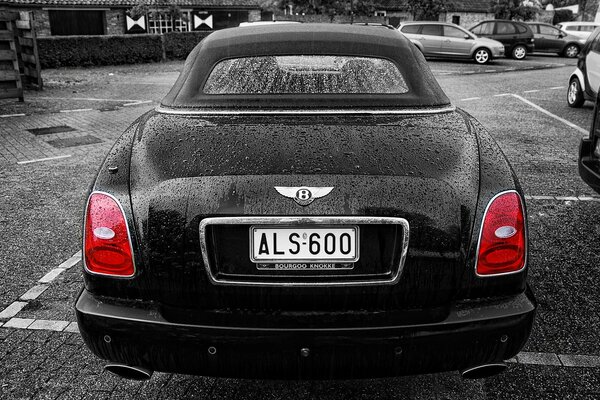 Cara Bentley con fari rossi nel parcheggio in bianco e nero