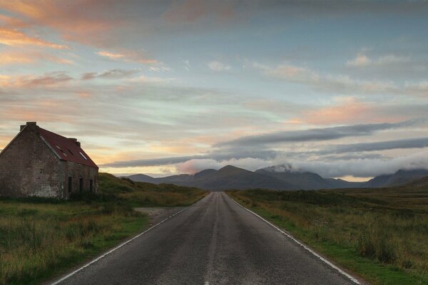 A deserted road. Abandoned house by the road