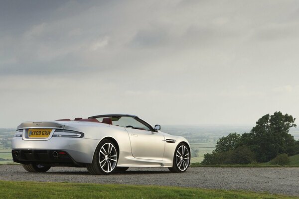 Silver convertible on a hill. Grey sky