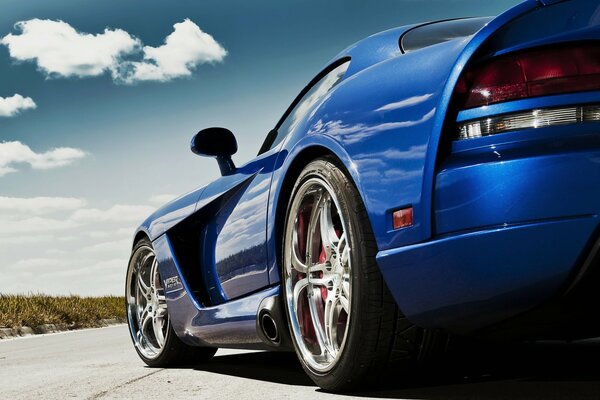 Blue dodge viper on the road under a blue sky