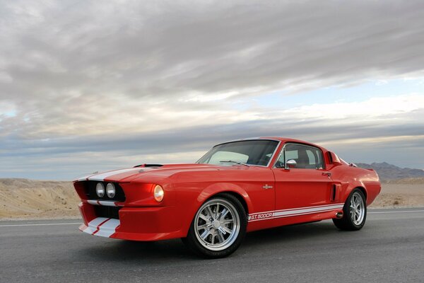 Mustang rojo en la carretera en medio de las nubes