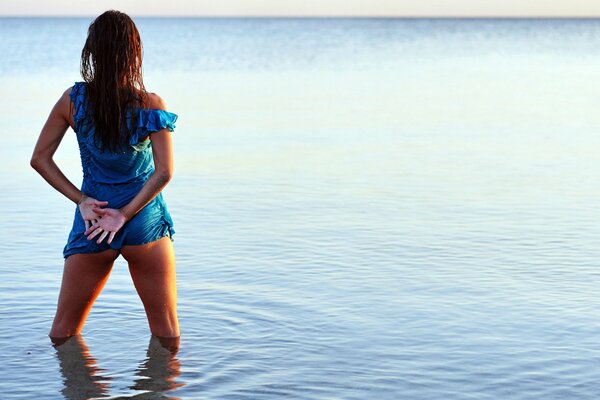 A girl on the sea looks into the distance