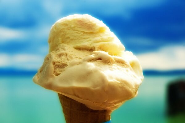 Yellow ice cream cone on the background of the sea