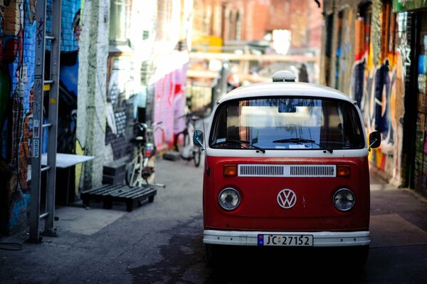 Ein roter VW-Transporter in einer engen Gasse der Stadt