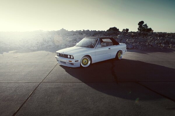 White car with black roof on the background of nature