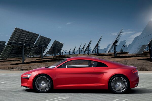 En la carretera hay un coche rojo con paneles solares