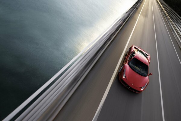 A red Ferrari is in motion on the highway