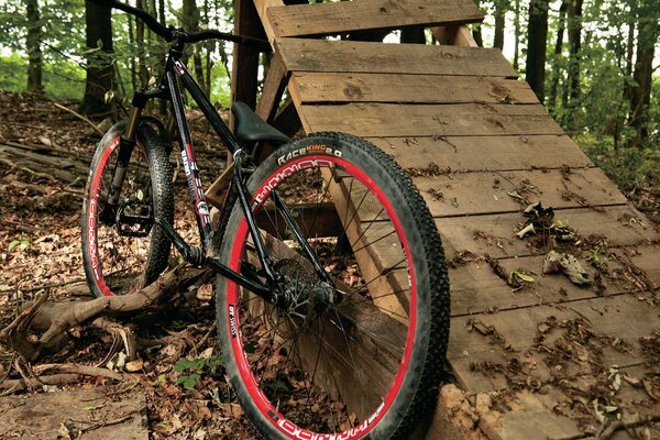 Street велосипед в лесу прислоненный к сломанной рампе для прыжков