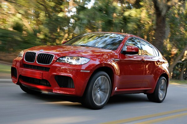 Coche rojo BMW X6 ruedas en movimiento