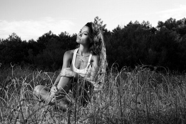 A cute girl is resting on the field