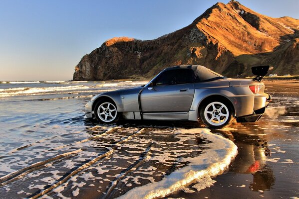 Coche plateado en la línea de surf