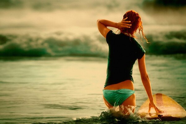 A girl with red hair and riding a surfboard