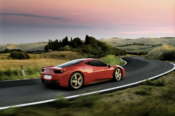 A red car is driving on the highway