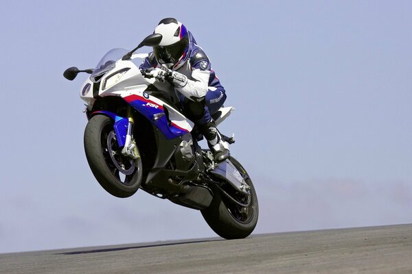 Athlète motocycliste costume blanc et bleu sur la course