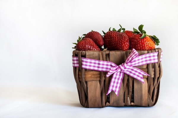 Auf weißem Hintergrund steht ein Korb mit Erdbeeren