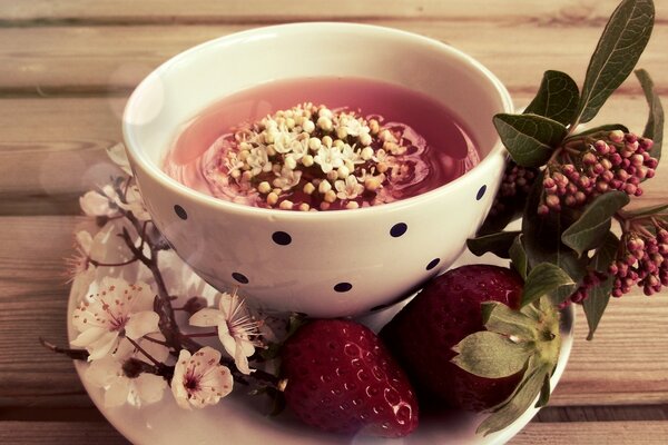 Tasse Tee mit Sakura und Erdbeeren verziert