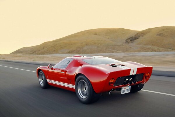 A red sports Ford racing down the road