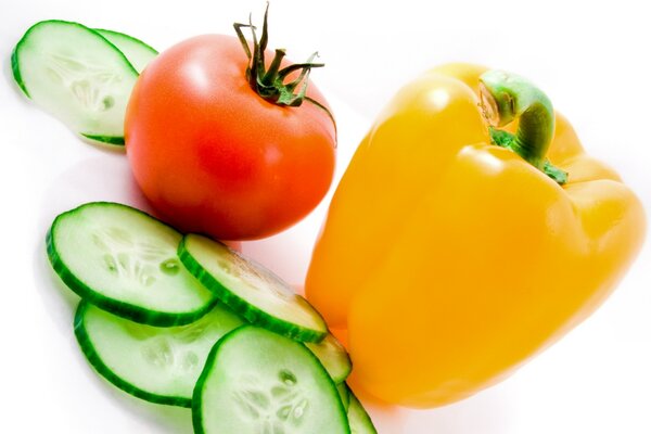 Légumes concombre tomate et poivre sur fond blanc