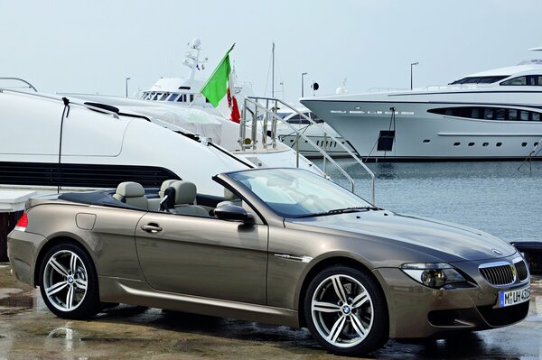 BMW convertible grey on the background of yachts