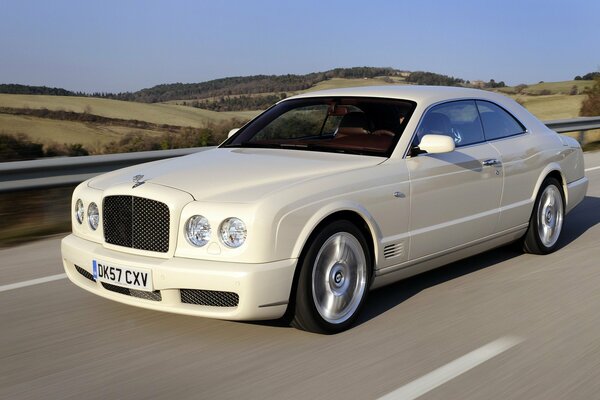 Bentley blanco como la nieve en el camino en el desierto