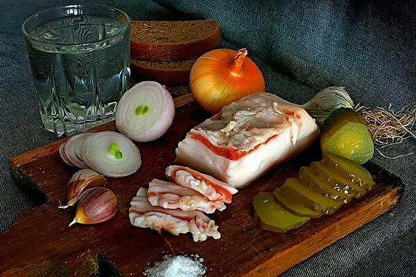 Still life glass filled with lard garlic pickled cucumbers onion