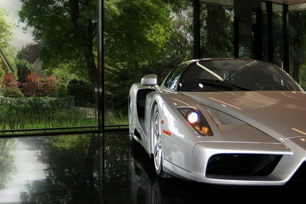 Mother-of-pearl Ferrari on the background of a green forest