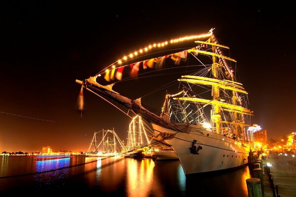 A chic ship docks against the background of the evening city