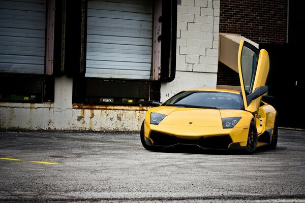 A parked lamborghini with the driver s door open