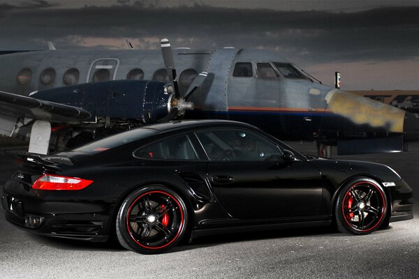 Black Porsche near planes