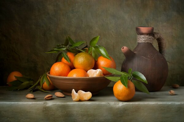 Nature morte: oranges dans une tasse et un pichet