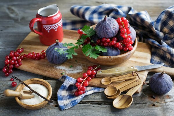 Rote Johannisbeere auf einer Tafel mit Zucker und Feigen