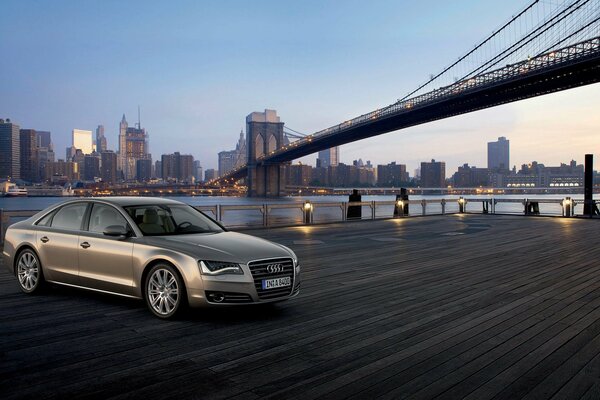 Against the background of the bridge and skyscrapers - a silver Audi