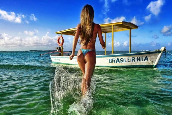 Slender girl walks to the boat on the water