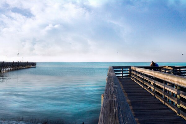 Pier with blue water in the sea on the horizon