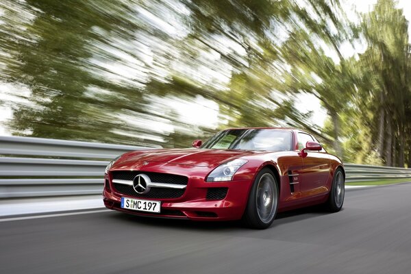 Un Mercedes rojo va rápido por la carretera