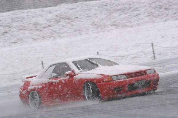 Nissan sulla strada alla velocità nella neve