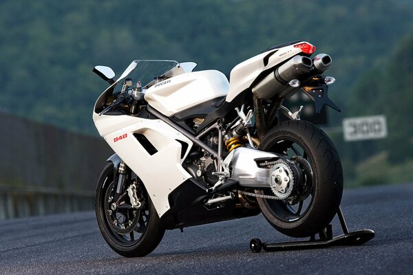 Ducati moto blanche sur route de montagne