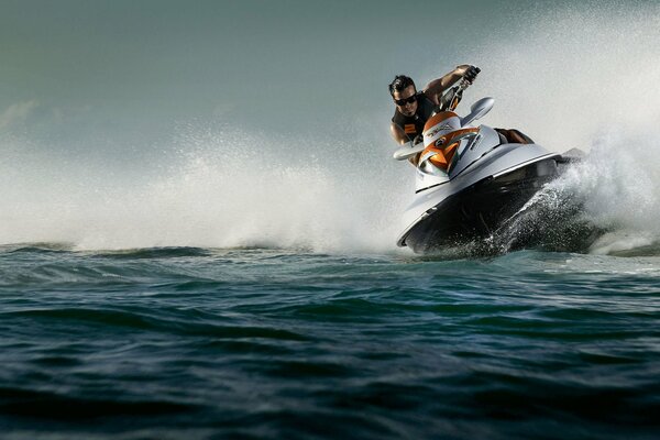 Jet Ski disecciona las olas hasta salpicaduras en los lados vuelan