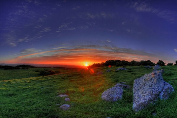 Stones in a field against a sunset background