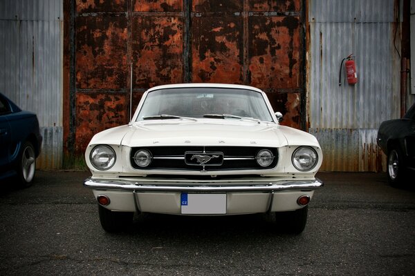 Alter Ford Mustang vor dem Hintergrund eines alten Tors