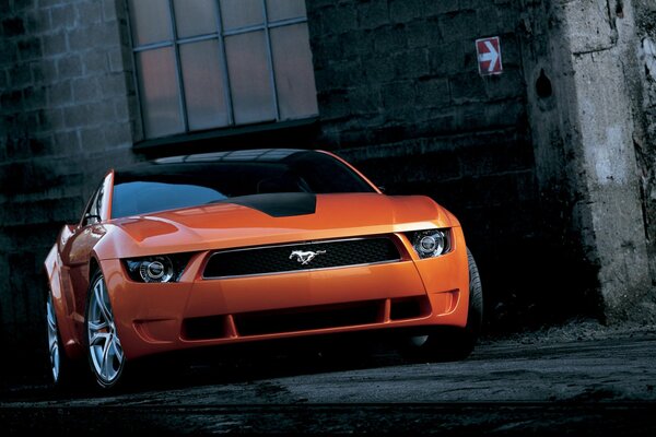 Foto orange ford mustang giugiaro in einer Gasse