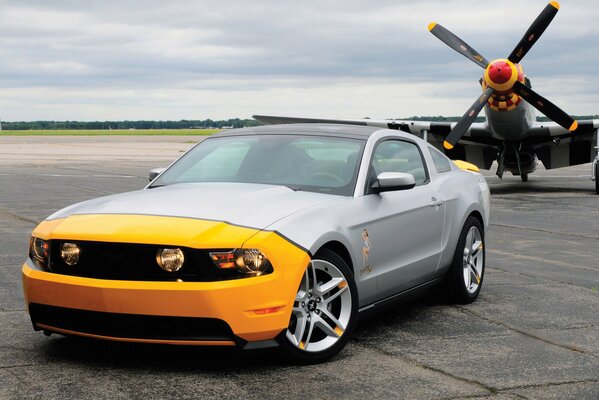 Ford Mustang na tle samolotu