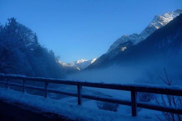 Winter, snow-capped mountains, trees in frost