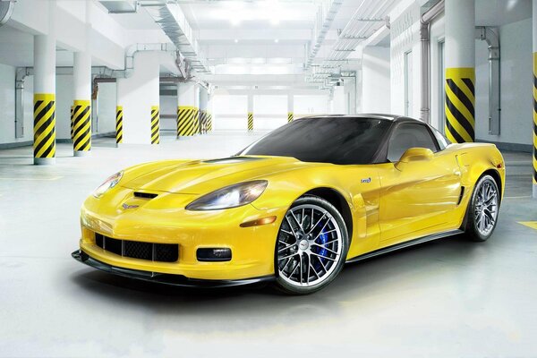 A yellow corvette is parked in the parking lot