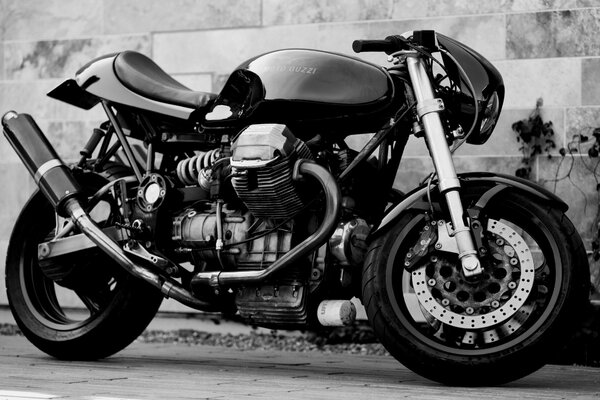 A sports motorcycle against the wall in black and white